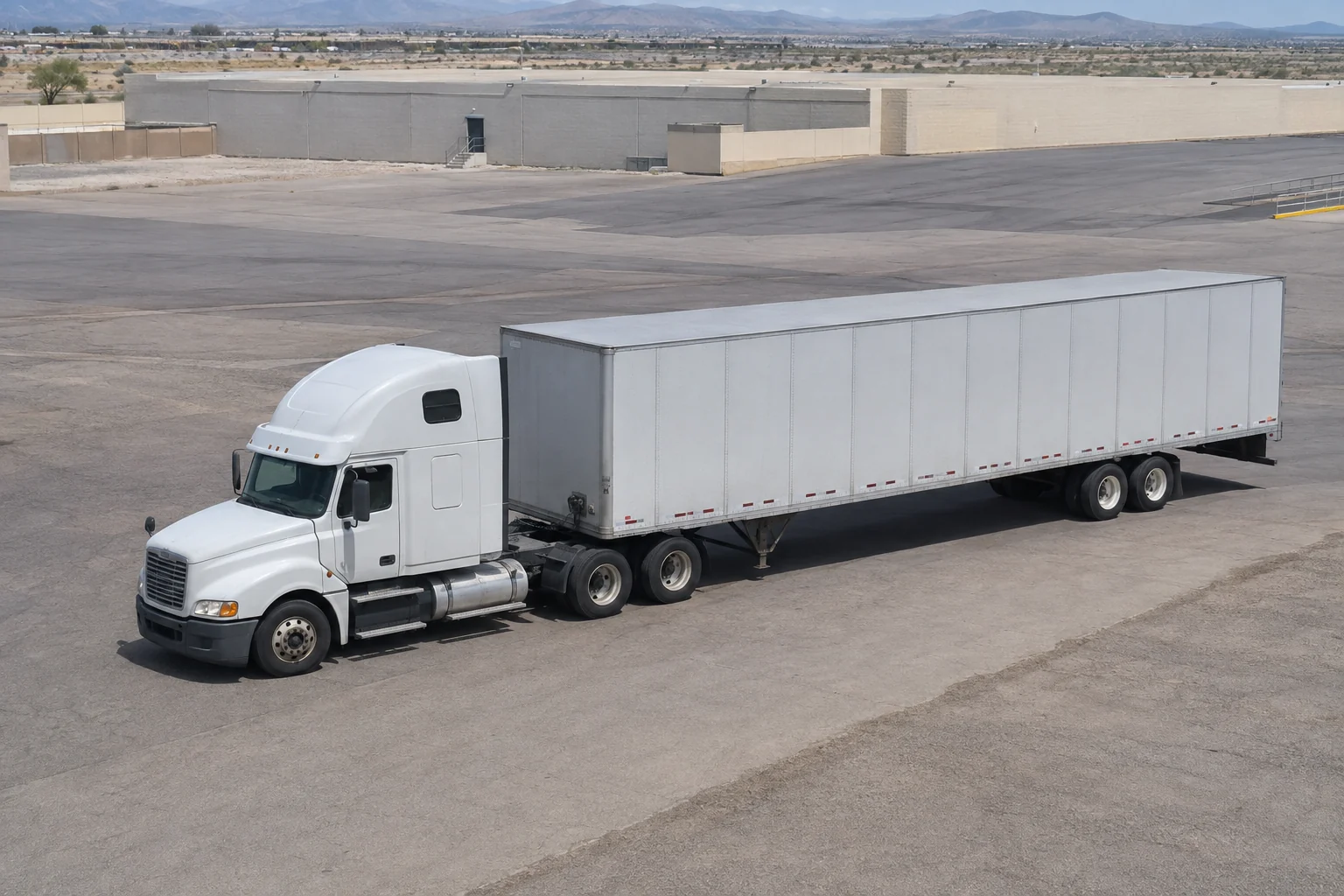 An unbranded tractor-trailer maneuvering through a Las Vegas industrial logistics yard